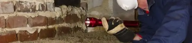 Pest control technician inspecting a crawl space for ant activity and entry points in Tempe, AZ