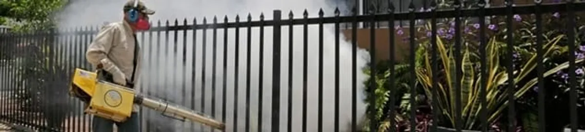 Mosquito control technician fogging a yard perimeter for mosquito reduction in Tempe, AZ